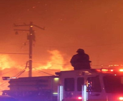 A firefighter looking towards an inferno of a hill in the palisades neighborhood during the height of the fires in early January. 