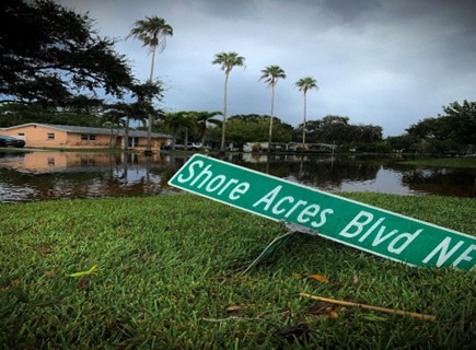 The shore acres boulevard sign next to receding floodwater after it was removed by storm surge during hurricane Helene.