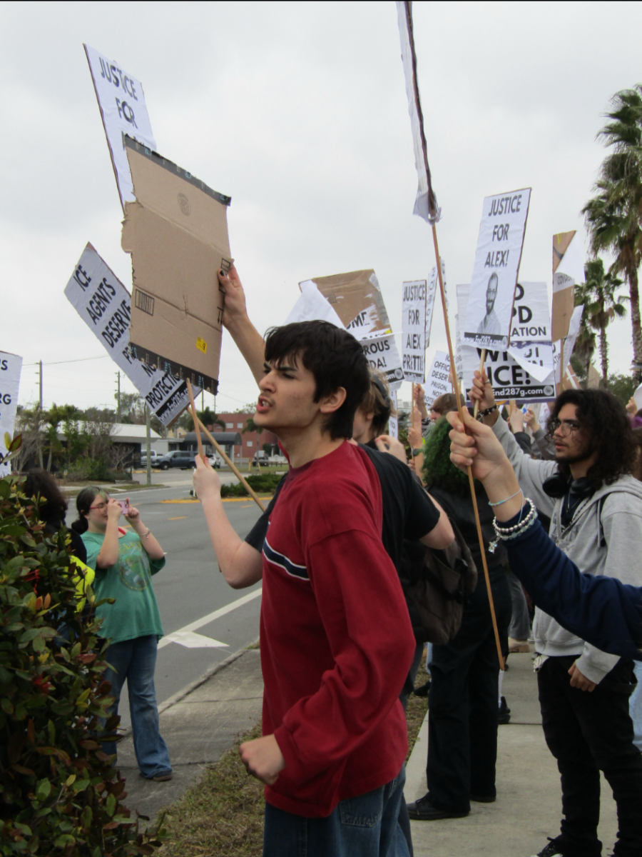 Students hold signs of protest at the front entrance of the school.